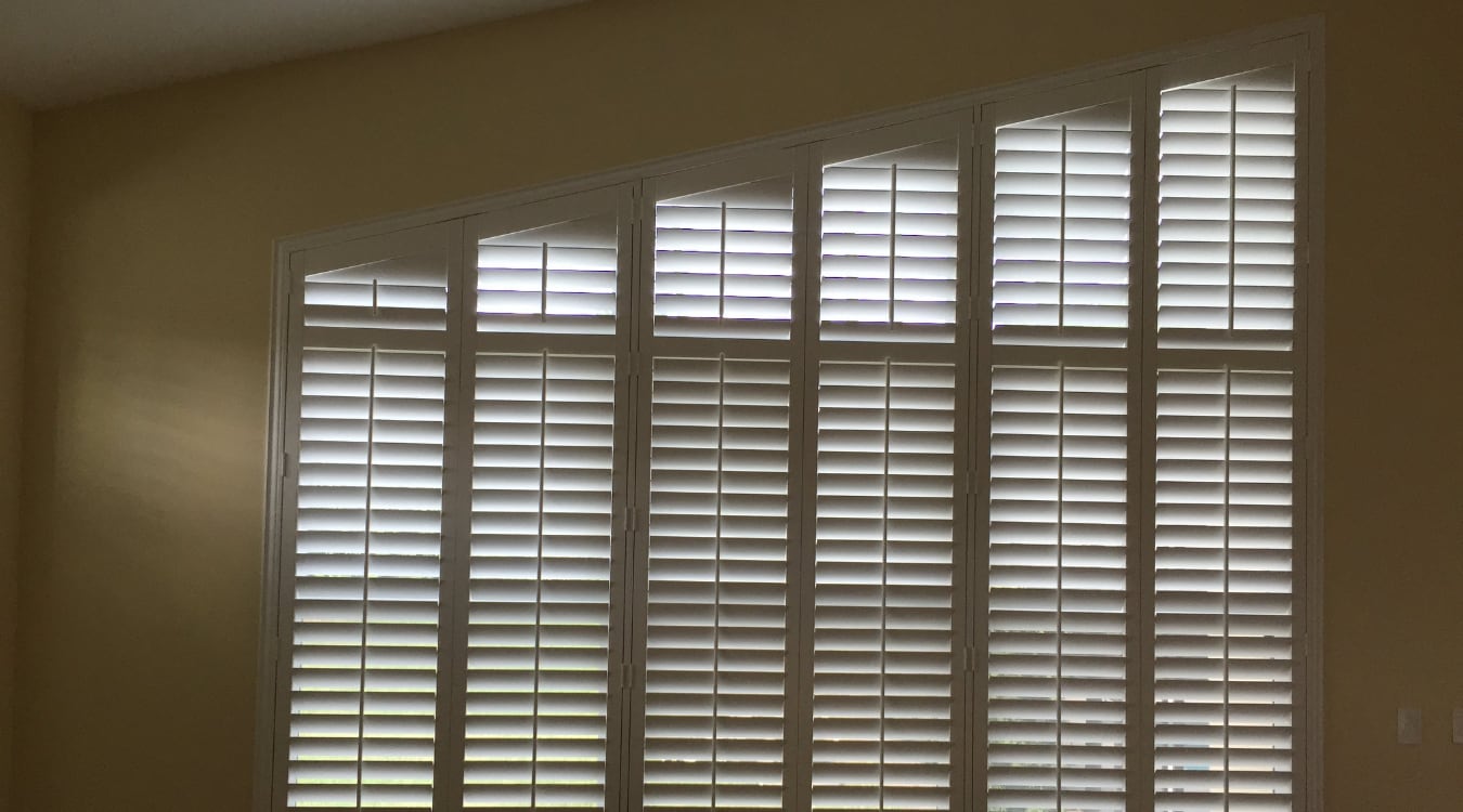 Angled window with plantation shutters